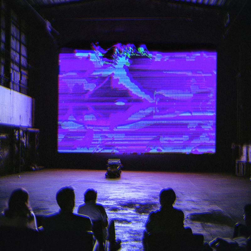 Visuals coming out of the screen at a screening in a industrial setting.